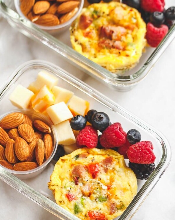 “Keto lunch meal prep with chicken, scrambled eggs, vegetables, and almonds in a glass container”
